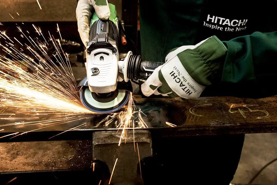 imagen de un trabajador moliendo una barra de acero plana